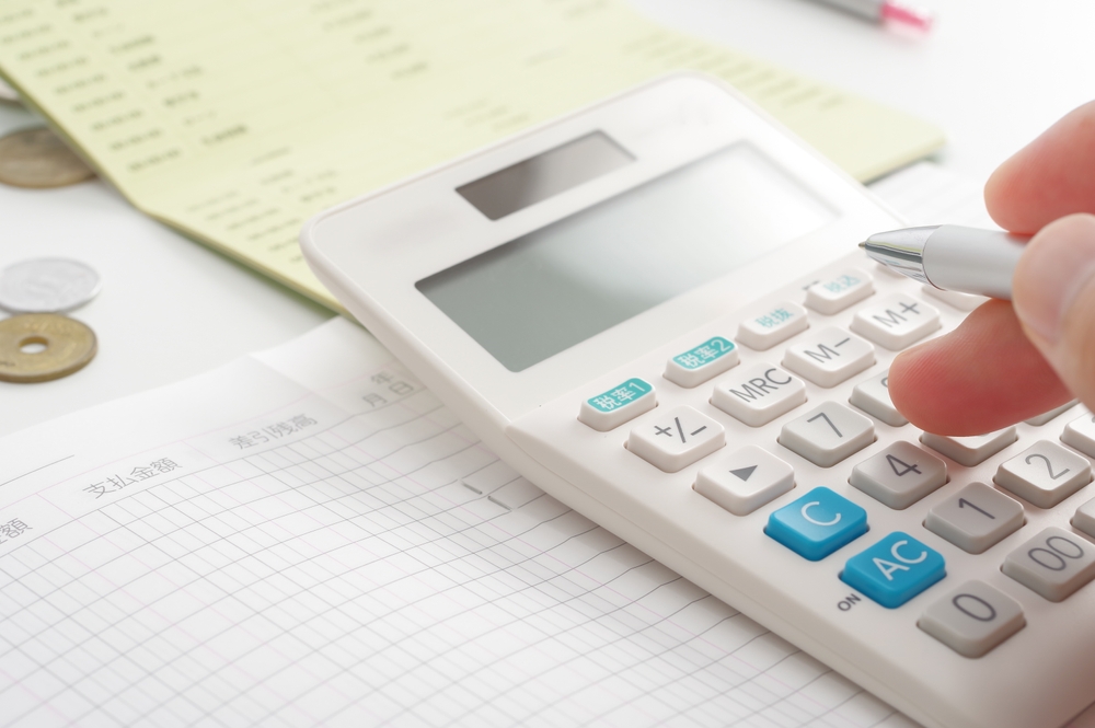 計算機を使って帳簿を記入している所