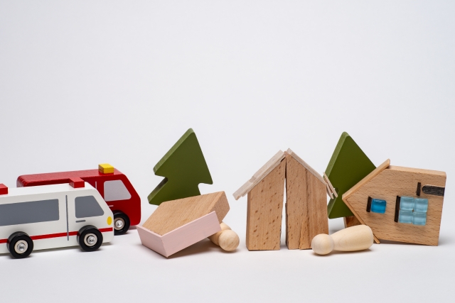 倒壊した家や倒れた人のミニチュアで災害現場を表現し、救急車のおもちゃが駆けつけている様子