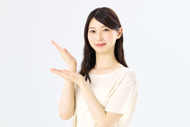 両手を広げて案内・紹介ポーズをとる女性
