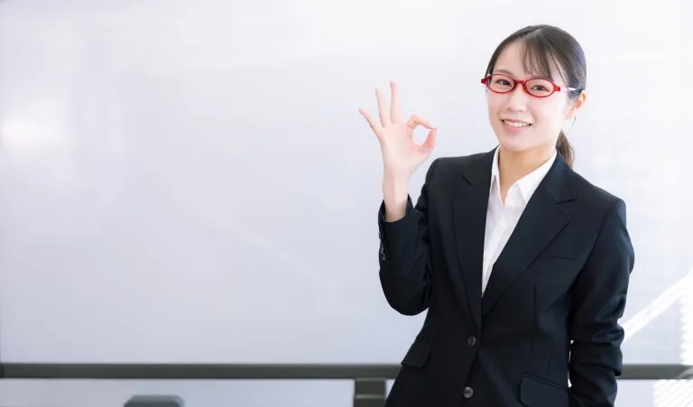 OKサインをするスーツ姿の女性