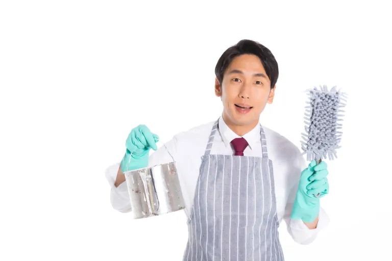 エプロンをつけ掃除道具を持った男性