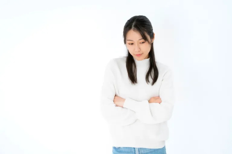 腕を組んで考え込む女性