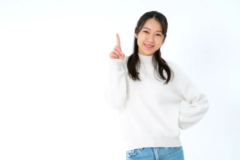 笑顔で人差し指を立てている女性