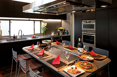 黒を基調としたキッチン。ガスオーブンが内蔵されている壁面部分は、食器やテーブルウェアなどを収めるための大容量の収納になっています。